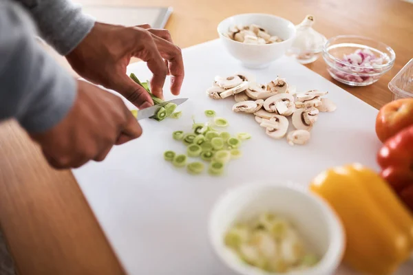 The start of a delicious dinner. Cropped shot of an unrecognizable chopping vegetables at home. — Stock Photo, Image