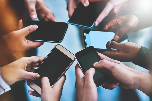Nehmen Sie Kontakt zu den Menschen in Ihrem sozialen Netzwerk auf. Schnappschuss einer Gruppe von Menschen, die ihre Telefone zusammen benutzen. — Stockfoto