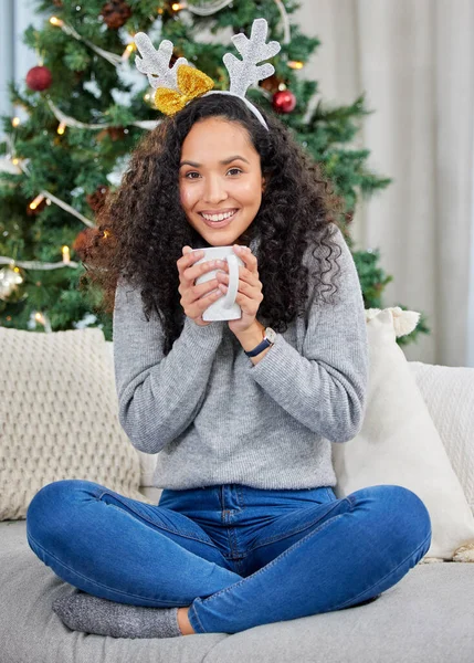 Evdeki sıcacık ortam. Evde Noel zamanı kahve içen genç bir kadının fotoğrafı.. — Stok fotoğraf