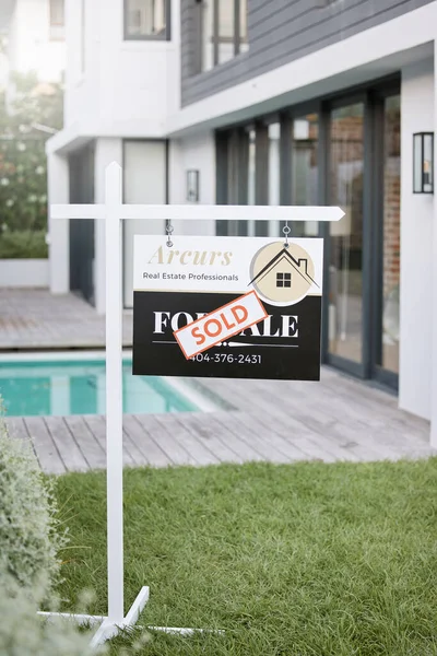 El hogar es la palabra más bonita que hay. Shot of en venta signo con una pegatina vendida fuera de una casa. — Foto de Stock