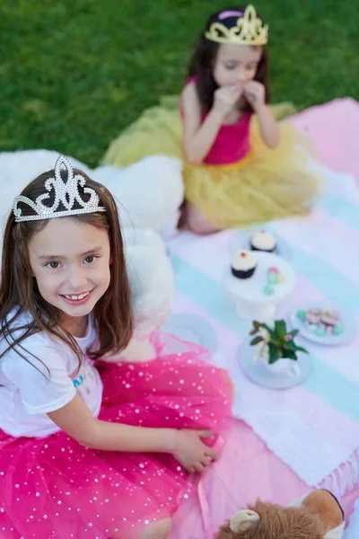 Zelfs prinsessen houden van picknicks. Portret van een klein meisje met een picknick met haar zus buiten. — Stockfoto