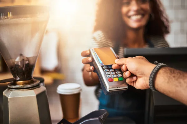 La manera inteligente, sin esfuerzo y fácil de pagar. Primer plano de un cliente haciendo un pago con tarjeta de crédito en un café. — Foto de Stock