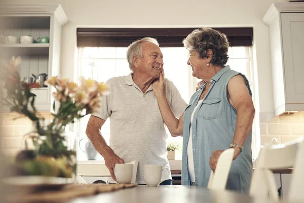 Cada toque es tan suave como siempre. Toma de una pareja de ancianos desayunando juntos en casa. — Foto de Stock