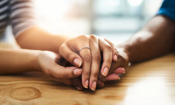 La amabilidad puede cambiar a alguien todo el día. Recorte de un hombre y una mujer no identificables tomados de la mano en una mesa. —  Fotos de Stock