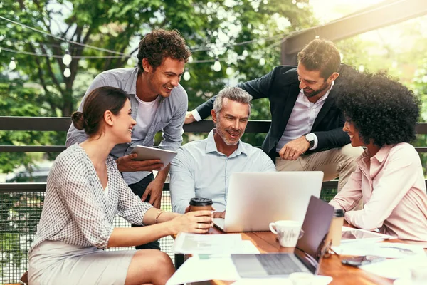 Sie treffen sich, planen und verwirklichen es. Aufnahme eines Teams von Kollegen mit einem Laptop während einer Besprechung im Freien. — Stockfoto