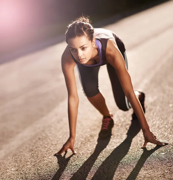 Το σώμα επιτυγχάνει αυτό που πιστεύει το μυαλό. Πυροβολισμός μιας νεαρής γυναίκας στην αρχική θέση για τρέξιμο.. — Φωτογραφία Αρχείου