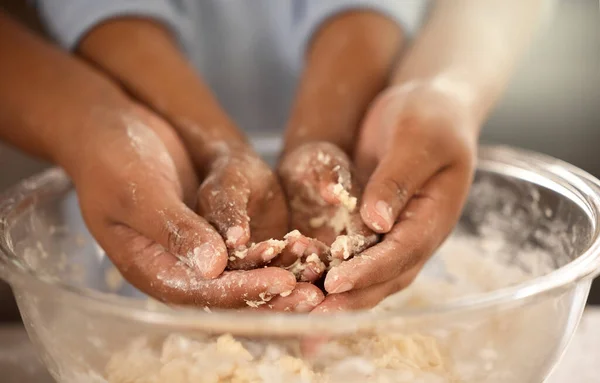 I bambini imparano sporcandosi. Colpo ritagliato di un padre e di un figlio irriconoscibili che si coprono le mani nella pastella dei biscotti mentre cuociono insieme a casa. — Foto Stock