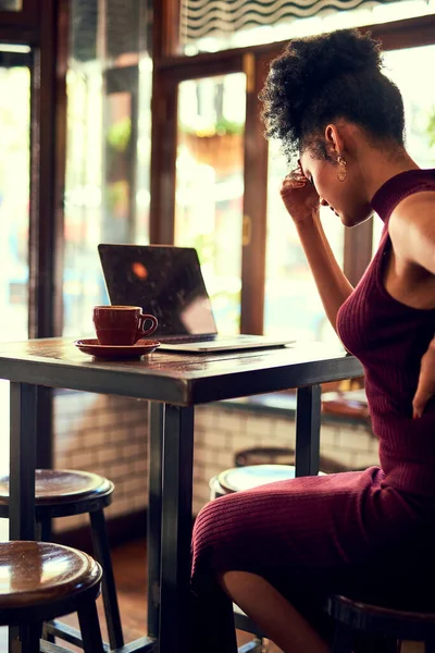 Luttant pour surmonter son agonie. Plan recadré d'une jeune femme éprouvant de l'inconfort pendant qu'elle travaillait sur son ordinateur portable dans un café. — Photo