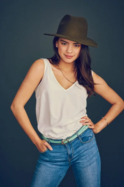 Lleva un sombrero como un profesional. Foto de estudio de una atractiva joven con sombrero y posando sobre un fondo oscuro. —  Fotos de Stock