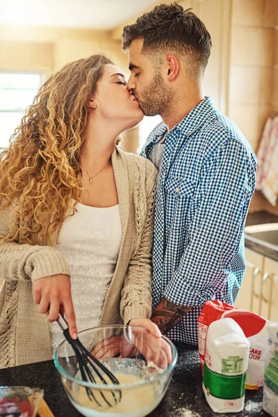 A receita diz um beijo apaixonado. Tiro de um casal amoroso assar em sua cozinha. — Fotografia de Stock