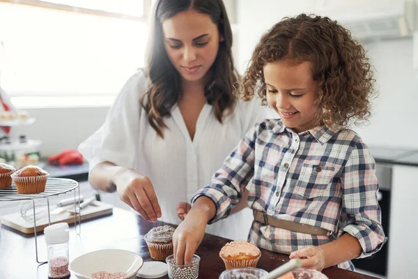 Geen band zoals moeder en dochter. Shot van een schattig klein meisje bakken met haar moeder thuis. — Stockfoto