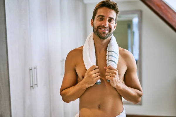 Está na hora de tomar um duche. Tiro de um jovem bonito segurando uma toalha em torno de seu pescoço em casa. — Fotografia de Stock