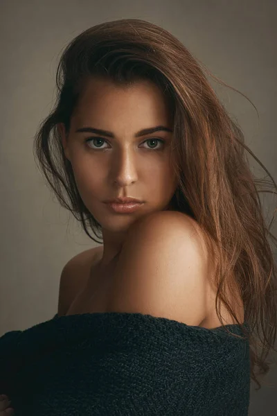 Schoonheid in eenvoud. Portret van een mooie jonge vrouw poseren tegen een bruine achtergrond in studio. — Stockfoto