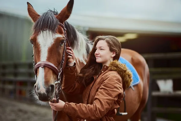 Son poney, son premier amour. Tourné d'une adolescente debout à côté de son poney sur une ferme. — Photo