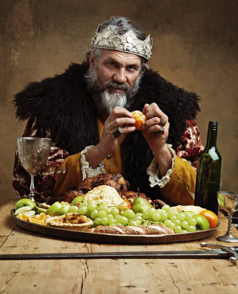 Its good to be the king. A mature king feasting alone in a banquet hall. — Stock Photo, Image