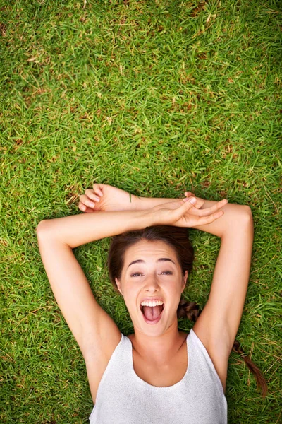 Pas de tristesse estivale ici. Prise de vue aérienne d'une jeune femme allongée sur l'herbe. — Photo