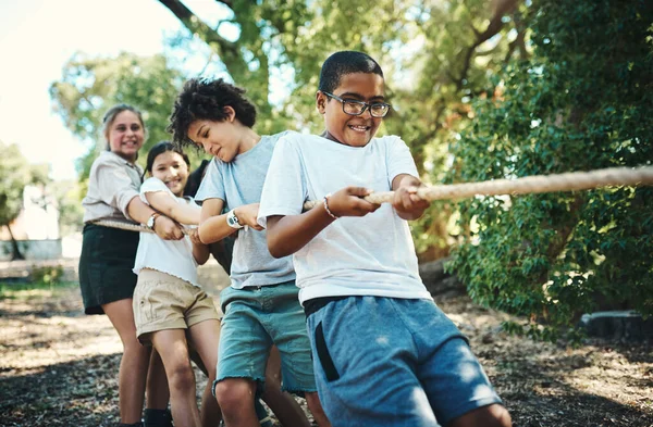 We wonnen allemaal toen we samen speelden. Schot van een groep tieners die een spelletje touwtrekken spelen op zomerkamp.. — Stockfoto