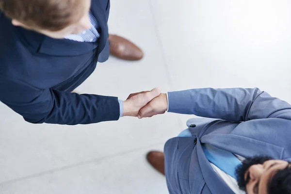 Vamos a crear mejores ideas juntos. Alto ángulo de tiro de dos empresarios irreconocibles estrechando la mano en una oficina corporativa. — Foto de Stock