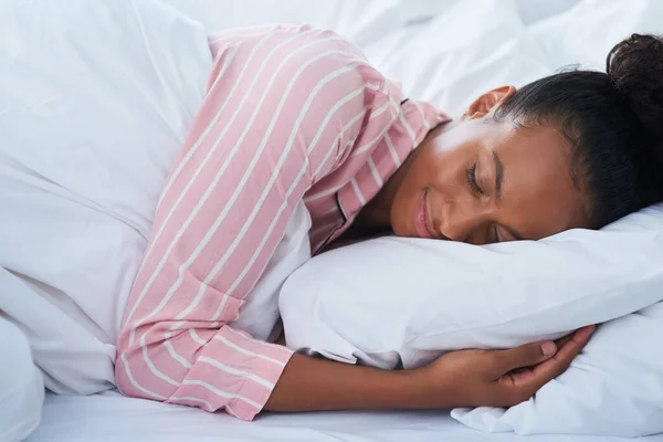 Schlafen wie ein Baby. Aufnahme einer attraktiven jungen Frau, die friedlich zu Hause im Bett schläft. — Stockfoto
