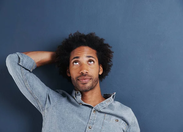 Just wondering.... Shot of a handsome young man looking up at copyspace on a gray background. — Stock Photo, Image