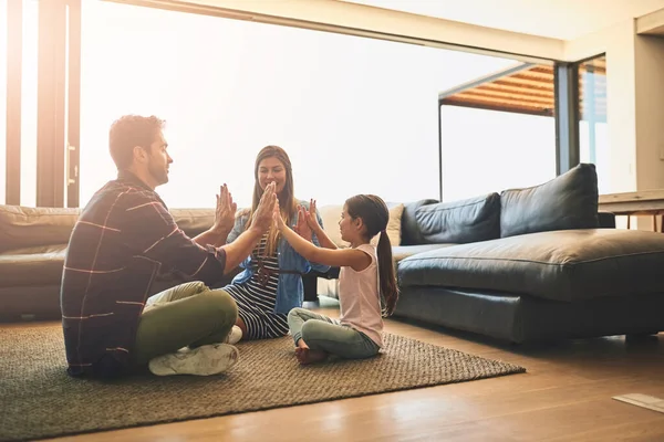 Сімейний час ще краще, коли ви розважаєтеся. Знімок щасливої сім'ї з трьох гравців, які грали разом вдома . — стокове фото