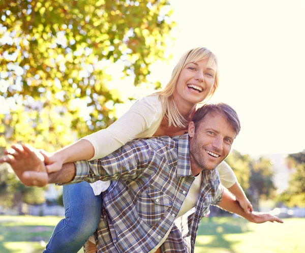 El amor te hace actuar como niños otra vez. Le dispararon a un hombre feliz apoyando a su esposa. — Foto de Stock