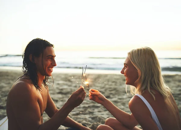 우린 아직 애들 일 수있어. 어느 행복 한 커플 이 석양에 해변에서 데이트를 하면서 반짝 이는 반짝 이는 불빛을 즐기고 있는 모습을 찍은 사진. — 스톡 사진