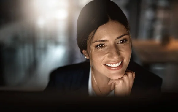 Smashing goals like the pro that she is. Shot of a young businesswoman working online during a late night in a modern office. — Stock Photo, Image