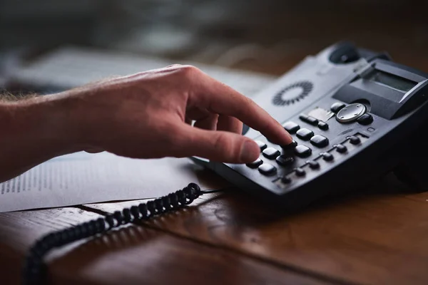 Le succès est à portée de main. Prise de vue d'un homme d'affaires non identifiable utilisant un téléphone de bureau dans le bureau. — Photo