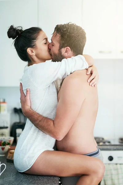 Şimdi gerçekten pişiyoruz. Sevgi dolu genç bir çiftin evlerindeki mutfaklarında samimi bir öpücük paylaşırken çekilmiş.. — Stok fotoğraf