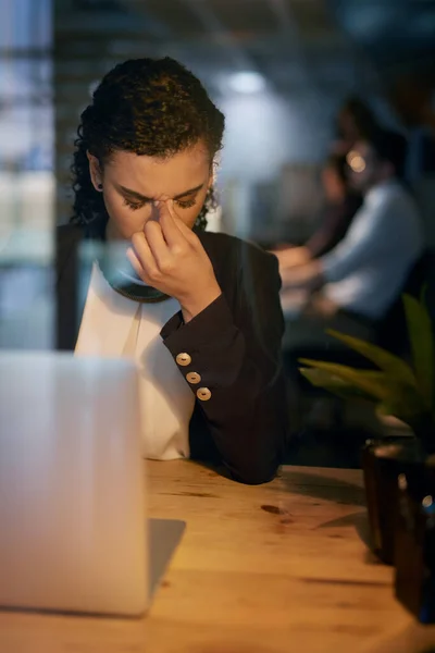 I wish I had time for a power nap. Shot of a tired businesswoman holding her head while working late in the office. — Stock Photo, Image