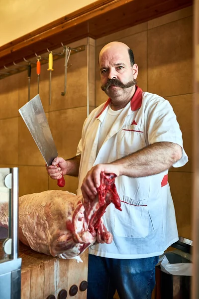 Vem ao meu talho, se quiseres carne de qualidade. Tiro de um açougueiro em sua loja. — Fotografia de Stock