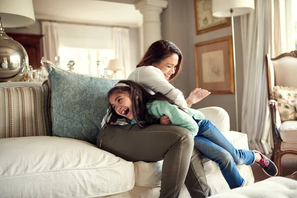 Anne ve kız anlarının eğlenceyle dolu olduğu anlar. Bir anne ve kızın evdeki kanepede eğlenmesi.. — Stok fotoğraf