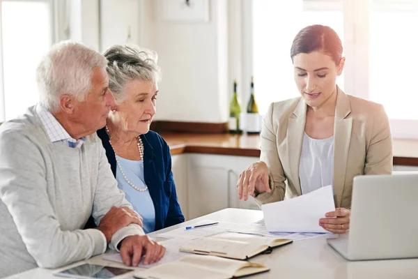 Voici vos chiffres financiers à ce jour. Plan recadré d'un couple de personnes âgées recevant des conseils de leur conseiller financier. — Photo