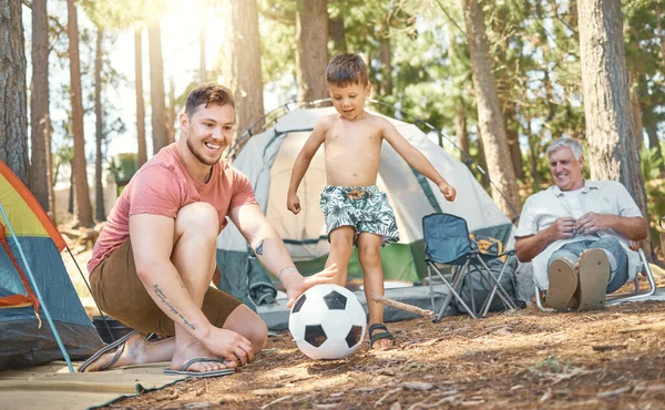 Só os rapazes. Filmagem completa de um menino adorável e seu pai brincando com uma bola de futebol enquanto acampava na floresta. — Fotografia de Stock