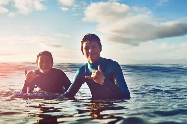 Laat de goede tijden en golven doorgaan. Schot van twee jonge jongens die aan het surfen zijn. — Stockfoto