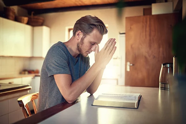 通过他的日常崇拜。拍了一个忠诚的年轻人双手合十祈祷打开圣经. — 图库照片