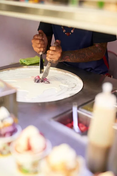 Haciendo su magia de comida. Inyección de un vendedor de alimentos no identificable preparando un dulce en un puesto de mercado. —  Fotos de Stock