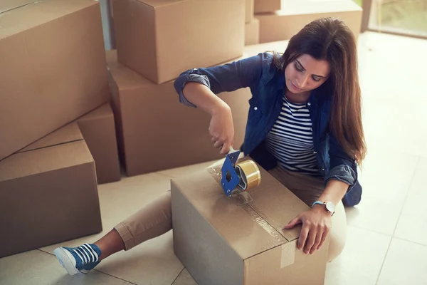 A selar os seus últimos pertences. Tiro de uma jovem mulher caixas de embalagem enquanto se move casa. — Fotografia de Stock
