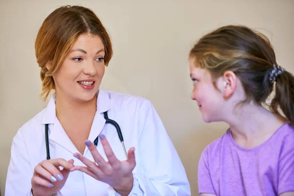 Erklärungen, die ihre junge Patientin verstehen kann. Aufnahme eines Kinderarztes, der ein kleines Mädchen in ihrem Büro untersucht. — Stockfoto