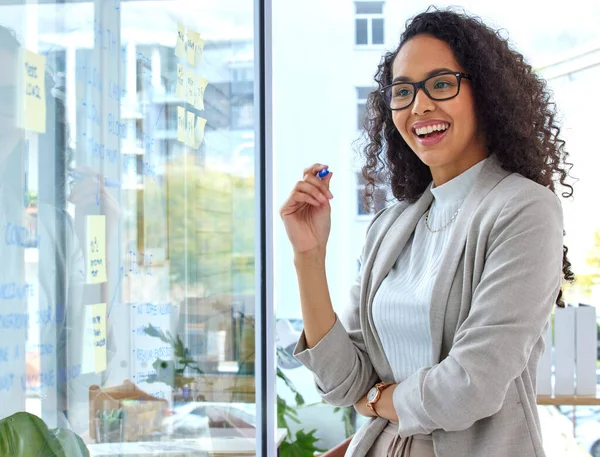 Genomför hennes planer till perfektion. Skjuten av en ung affärskvinna brainstorming med anteckningar på en glasskärm på ett kontor. — Stockfoto