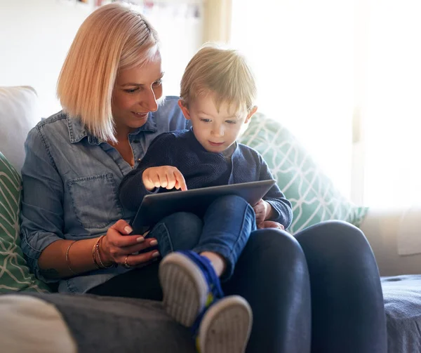 Regarder son dessin animé préféré ensemble. Plan recadré d'une mère et son fils utilisant une tablette numérique ensemble à la maison. — Photo