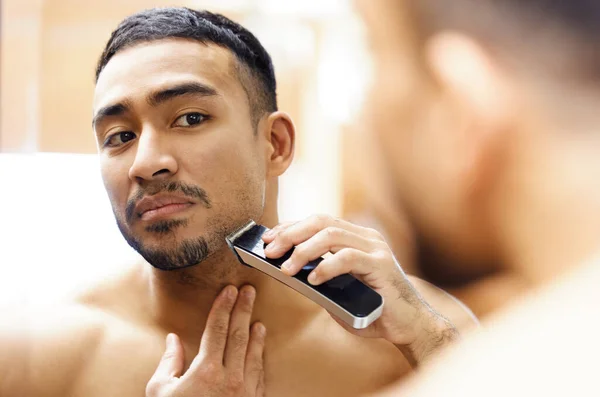 My date wont even recognise me tonight. Shot of a young man using an electric shaver. — Stock Photo, Image