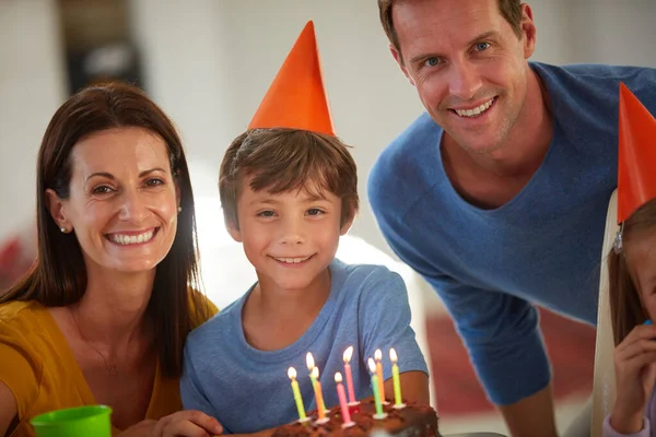 Vandaag is onze zoons speciale dag. Portret van een gelukkig gezin met een verjaardagsfeestje thuis. — Stockfoto