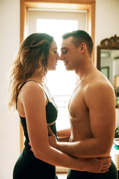 Las mañanas son para el romance. Foto de una pareja joven y cariñosa pasando una romántica mañana juntos en casa. —  Fotos de Stock