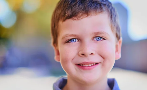 Er ist ein glücklicher Junge. Porträt eines entzückenden Jungen draußen. — Stockfoto