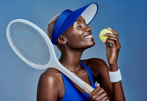 Jouer au tennis m'a rendu meilleur. Plan studio d'une jeune femme sportive posant avec du matériel de tennis sur fond gris. — Photo