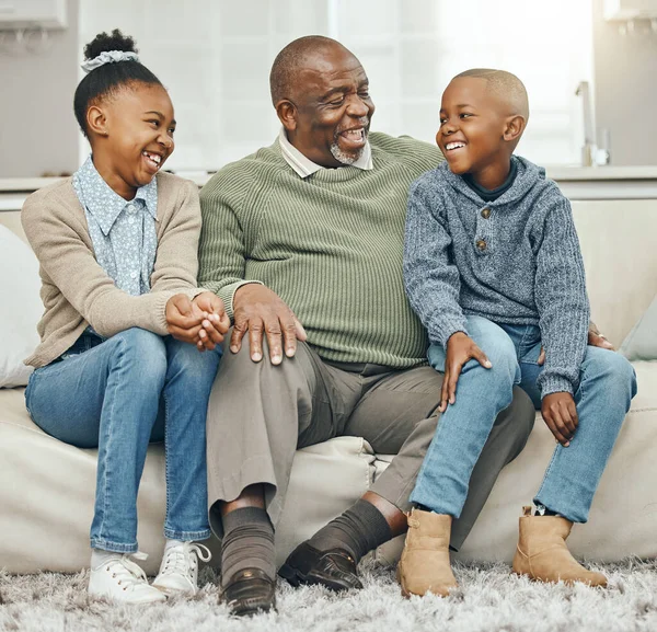 Era assim que fazíamos as coisas antigamente. Tiro de um avô se unindo com seus netos em um sofá em casa. — Fotografia de Stock