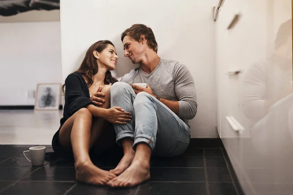 Je me sens chez toi dans tes yeux. Tourné d'un jeune couple affectueux assis sur le sol de la cuisine. — Photo