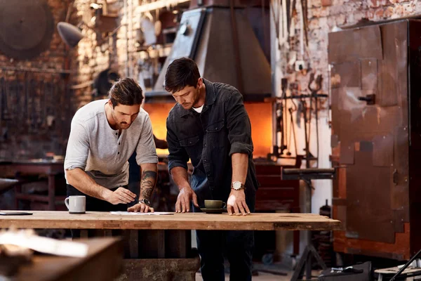 We verzinnen altijd manieren om ons bedrijf uit te breiden. Gehakte foto van twee knappe jonge zakenmannen die samenwerken in hun werkplaats. — Stockfoto